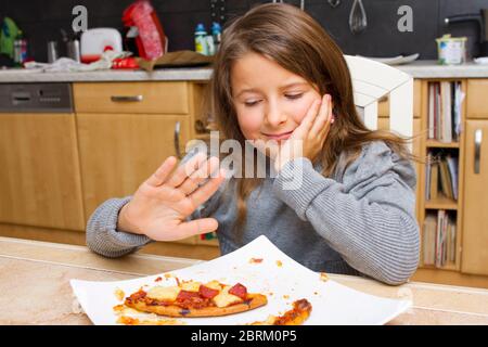 Kind vor Teller mit Pizzaresten, MR: Yes Stock Photo