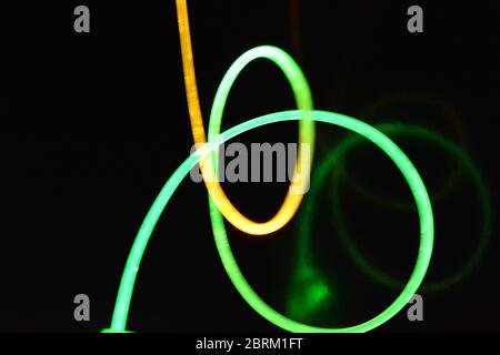 Wire with green and red light, a light guide wire with different light transmission, light spectrum, and light effects located in a chaotic state. Stock Photo