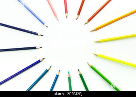 Bright beautiful crayons. Colored pencils in frame of circle isolated on white background. Stock Photo