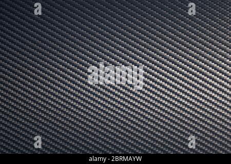 Close up of grey diagonal oriented woven carbon fibre sheet surface. Texture and pattern background. Modern technology and material concept... Stock Photo