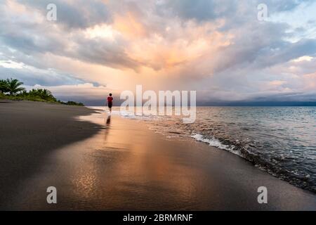Teen walking on beach with reflection in Costa Rica