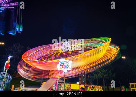 Roller coaster in motion amusement park at night. Long exposure