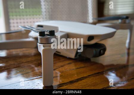 White drone sitting on wooden table. Up close product shot indoors. Stock Photo