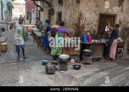 Street scene in Old Town Mombasa with women preparing food for sale Stock Photo