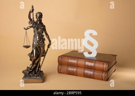 Justizia mit antiken Büchern auf beigem Hintergrund Stock Photo