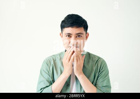 Asian handsome man over isolated background happy and smiling covering mouth with hands Stock Photo