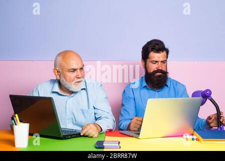 Office workers. Conversation between colleagues in office. Business man in office with colleagues. Couple of two office workers working at laptop scre Stock Photo