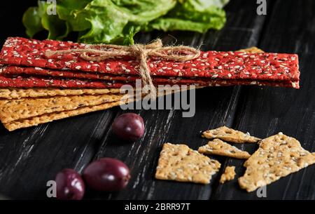 Beetroot and rye flour crackers with vegetables for making snacks on a black background. Vegetarianism and healthy eating. Stock Photo