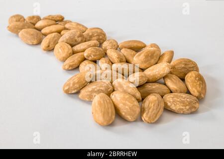 Group of peeled almond seeds on a white surface Stock Photo