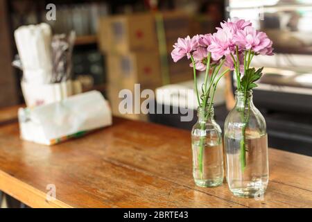 pink flower in frost on wet table of outdoor cafe. Romantic concept. Banquet background. Love concept. Lonely flower. Stock Photo
