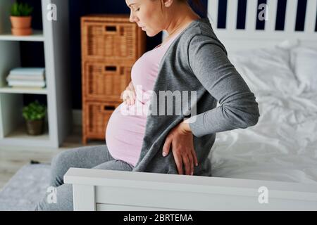 Pregnant woman feeling pain in the back Stock Photo