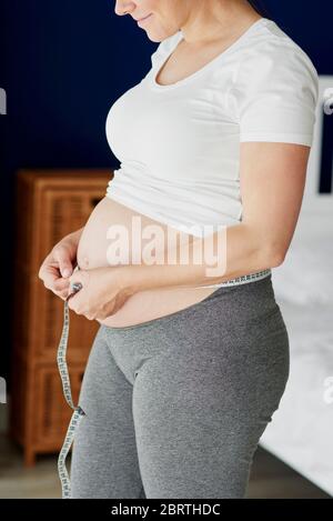 Pregnant woman measuring her abdomen Stock Photo