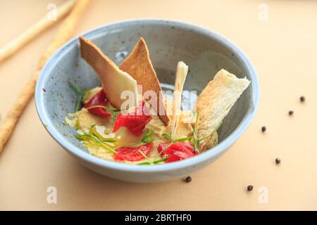 Bowl of homemade hummus pastel background from top view Stock Photo