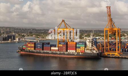 Bridgetown port with loading cranes and cargo ship being loaded with containers Stock Photo