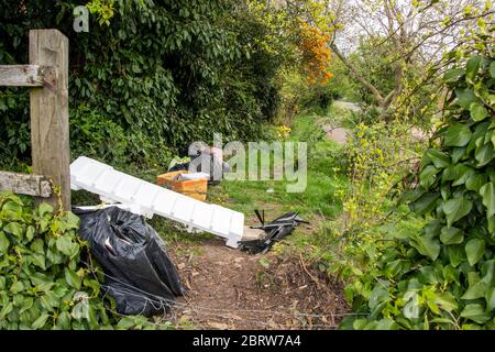 Sheffield UK –  April 09 2020: Fly tipped rubbish despoils an urban  wildlife area during the Covid-19 coronavirus pandemic at Fishponds Road Stock Photo