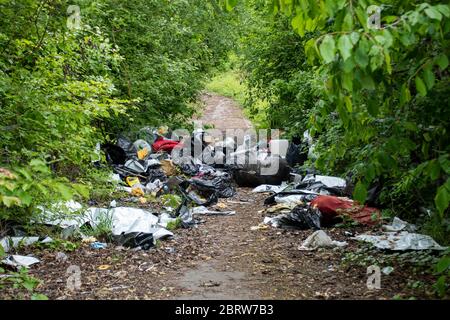 Sheffield UK –  May 13 2020: Fly tipped rubbish despoils an urban  pathway of ginnel during the Covid-19 coronavirus pandemic off Greenland Road Stock Photo