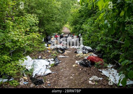 Sheffield UK –  May 13 2020: Fly tipped rubbish despoils an urban  pathway of ginnel during the Covid-19 coronavirus pandemic off Greenland Road Stock Photo
