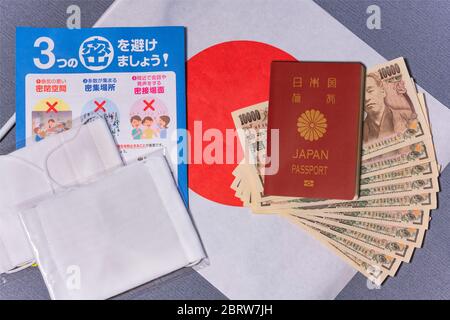 tokyo, japan - may 20 2020: Cloth masks with leaflet promoting social distancing and 100,000 yen in cash sent by the Japanese govt to fight coronaviru Stock Photo