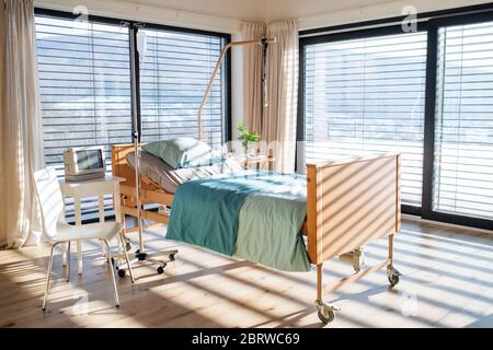 Empty, adjustable bed in room in private modern hospital. Stock Photo