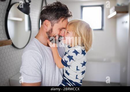 Mature father with small son indoors in bathroom, having fun. Stock Photo