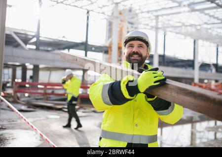 Men workers walking outdoors on construction site, working. Stock Photo