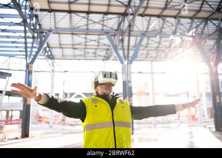 Man engineer using VR goggles on construction site. Stock Photo