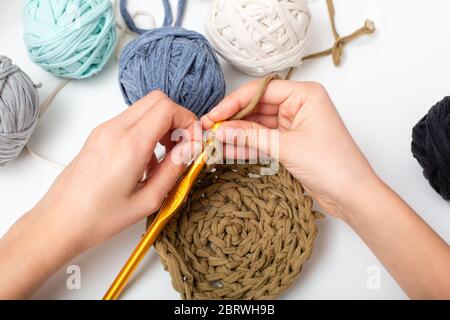 Different colored balls of yarn. Children's hands are crocheted and thread view frome above Stock Photo