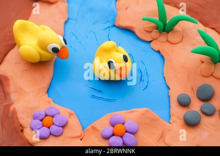 Two plasticine ducklings in a pond. Scene is made out of play clay. Stock Photo