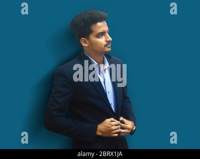 Portrait of fashionable handsome man in black suit . handsome man isolated on light blue background. Stock Photo