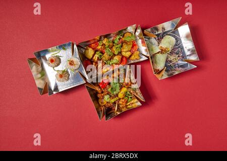 delicious chinese food in takeaway boxes on red Stock Photo