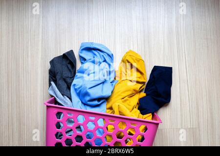 Clothes in pink plastic laundry basket. Top view Stock Photo