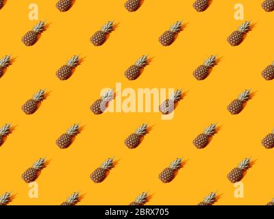 whole ripe pineapple on orange colorful background, seamless pattern Stock Photo