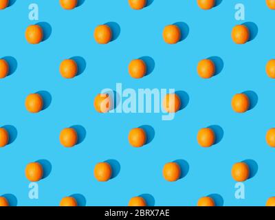 top view of ripe oranges on blue colorful background, seamless pattern Stock Photo