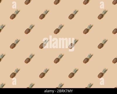 top view of whole ripe pineapples on beige background, seamless pattern Stock Photo