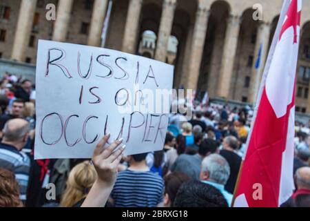 Tbilisi, Georgia - June 20, 2019: Georgian girl holding a poster 'Russia is an occipier'. Anti Russian protests in front of the Parliament of Georgia. Stock Photo