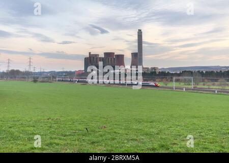 A virgin Trains west coast  Pendolino passes Rugeley power station on the west coast mainline. Stock Photo