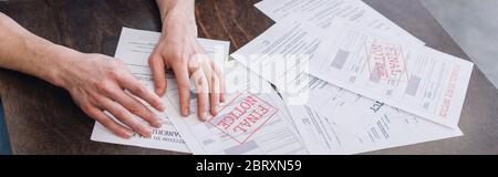 Cropped view of male hands near documents with foreclosure and final notice lettering on table, panoramic shot Stock Photo