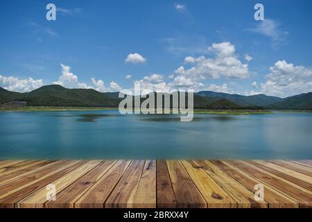 Perspective empty wood table top over dam and mountain with blue sky in background. For products display or design layout Stock Photo