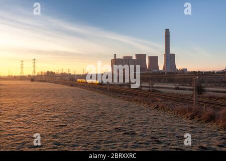 London Midland Siemens Desiro class 350 electric train passing the coal fired Rugeley power station on the electrified west coast mainline Stock Photo