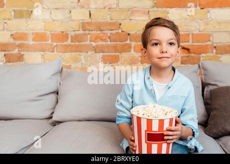 cute boy watching movie and holding popcorn bucket Stock Photo