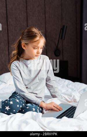 kid using laptop with e-learning in bedroom Stock Photo