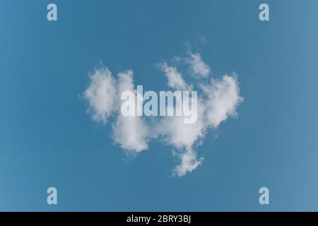 Single white cloud on blue sky background. Stock Photo