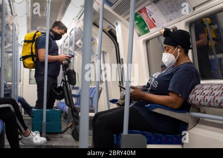 Commuters wearing face masks on the Jubilee line in central London, after the introduction of measures to bring the country out of lockdown. Stock Photo