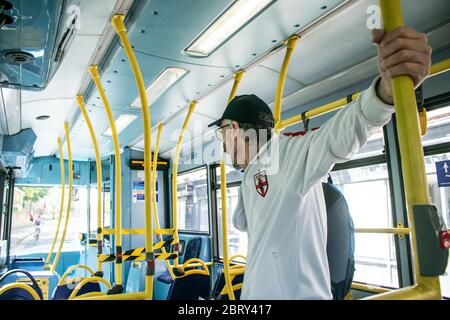 WIMBLEDON  LONDON,  UK. 22 May 2020. A passenger travelling on a London bus wearing a protective face mask against covid-19 infections. People have been advised to wear protective face coverings when using public transport and maintain a 2 metre social distance to stop the spread of coronavirus . Credit: amer ghazzal/Alamy Live News Stock Photo