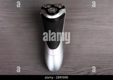 Minimalist still life of an electric shaver on a wooden background Stock Photo