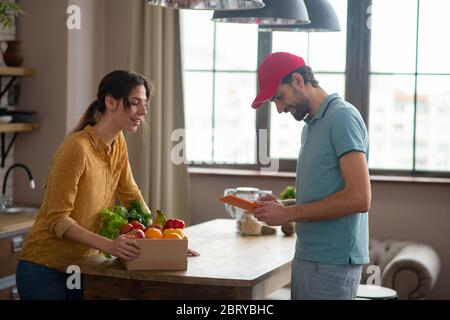 Woman receiving home food delivery from a courrier Stock Photo