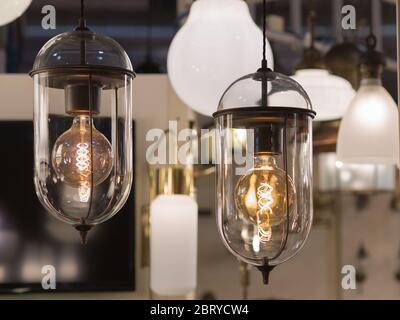 Two Bulbs Hanging: Vintage Electric Light Bulb with Incandescent Filament. Stock Photo