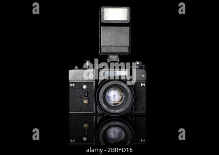 One whole camera with flash isolated on black glass Stock Photo