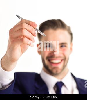 Business stationery concept. Man with smiling face writes in air, defocused. Businessman holds pen in air, close up. Man in suit or businessman shows luxury pen isolated on white background. Stock Photo