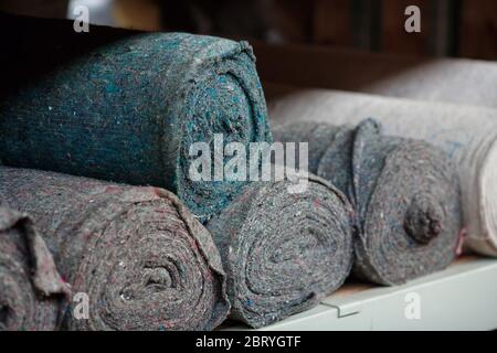Covering non-woven material in rolls on the shelves of the warehouse. Stocks of cloth and rags. Copy space Stock Photo